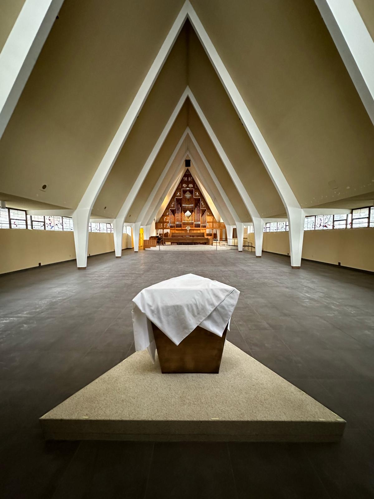 Renovated church sanctuary with soaring white A-frame arches and a pipe organ