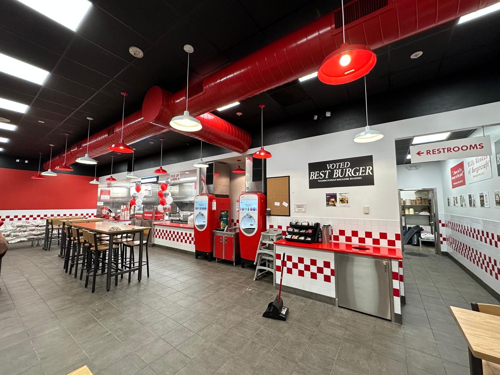 Five Guys dining area with high-top seating and brand finishes